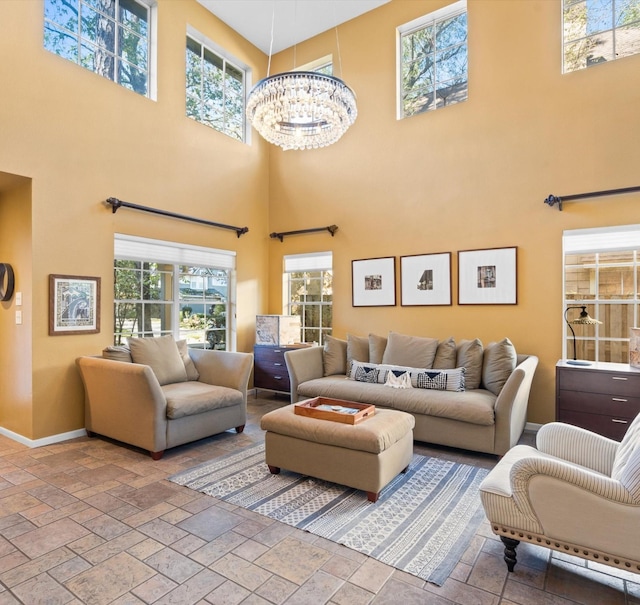 living room with a towering ceiling and a chandelier