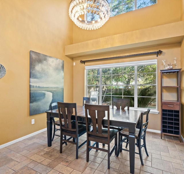 dining room featuring a high ceiling, a wealth of natural light, and a notable chandelier