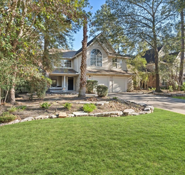 view of front property featuring a front yard, a porch, and a garage