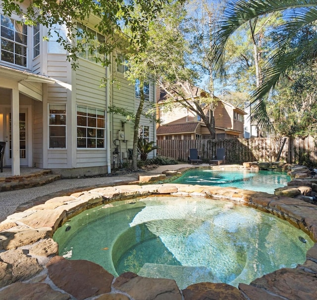 view of swimming pool with an in ground hot tub