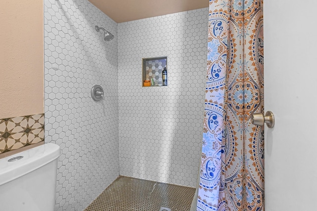 bathroom with a tile shower, decorative backsplash, and toilet