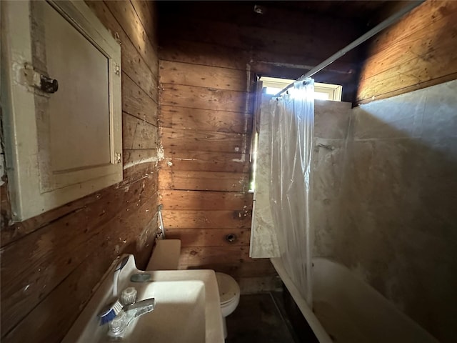 bathroom featuring wood walls, shower / bath combo, and toilet