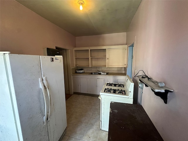 kitchen featuring white cabinetry, sink, light tile patterned flooring, and white appliances