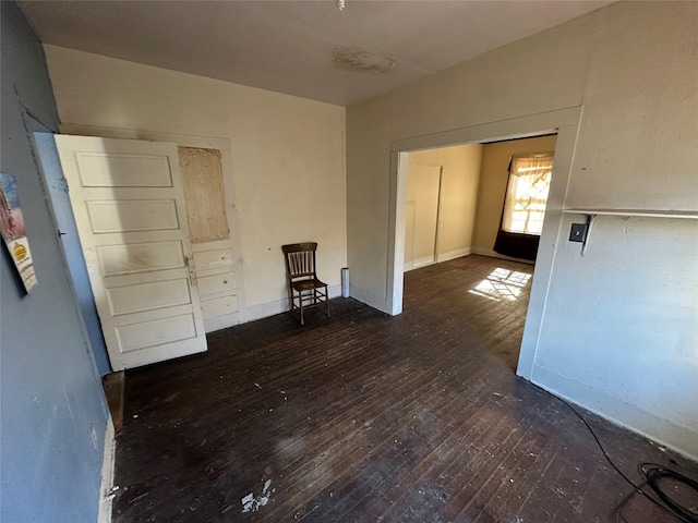 unfurnished room with dark wood-type flooring