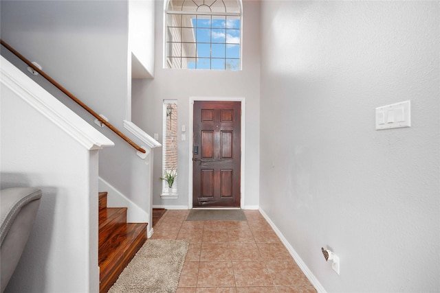 foyer with light tile patterned flooring and a towering ceiling