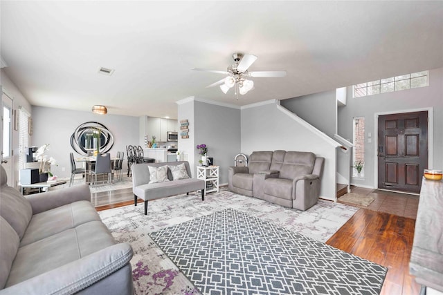 living room featuring ceiling fan, ornamental molding, and hardwood / wood-style flooring