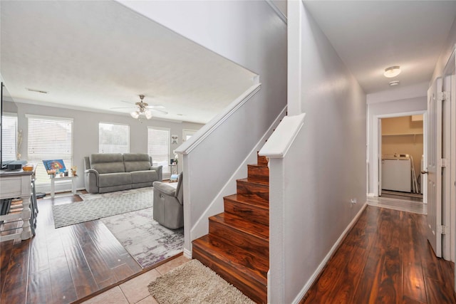 staircase featuring washer / dryer, ceiling fan, and wood-type flooring