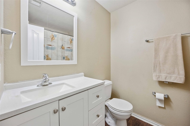 bathroom featuring hardwood / wood-style floors, vanity, and toilet