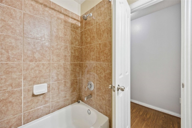 bathroom with hardwood / wood-style floors and tiled shower / bath combo