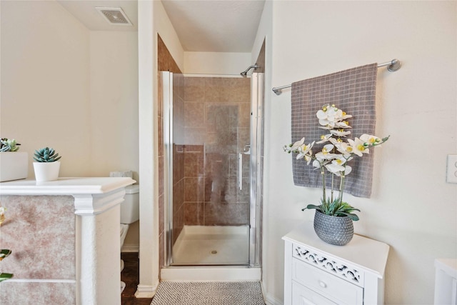 bathroom featuring tile patterned flooring, toilet, and walk in shower