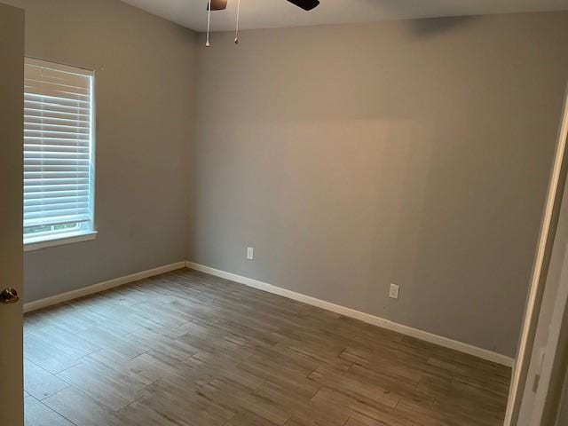 spare room featuring wood-type flooring and ceiling fan