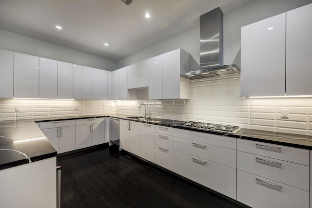 kitchen featuring white cabinets, stainless steel gas stovetop, and wall chimney range hood