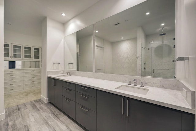 bathroom featuring hardwood / wood-style floors, vanity, and a shower with shower door