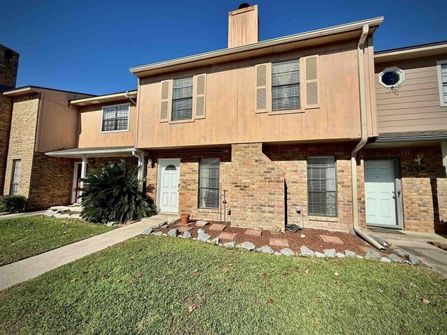 townhome / multi-family property featuring a front lawn