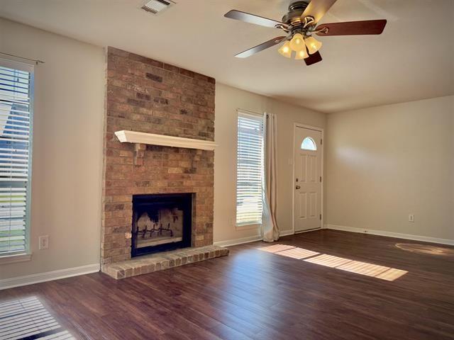 foyer with a fireplace, a wealth of natural light, dark wood-type flooring, and ceiling fan