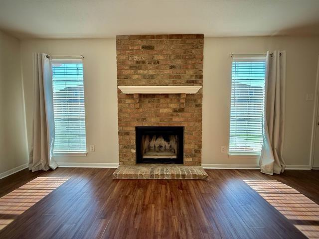 unfurnished living room featuring dark hardwood / wood-style flooring and a wealth of natural light