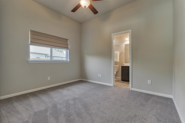 unfurnished bedroom with ensuite bathroom, ceiling fan, and light carpet