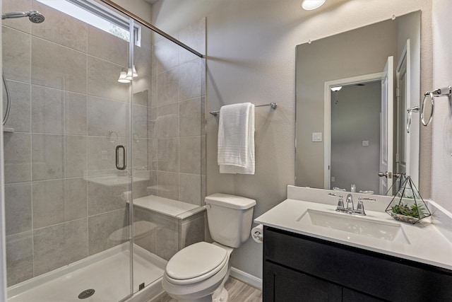 bathroom with vanity, hardwood / wood-style flooring, toilet, and a shower with shower door