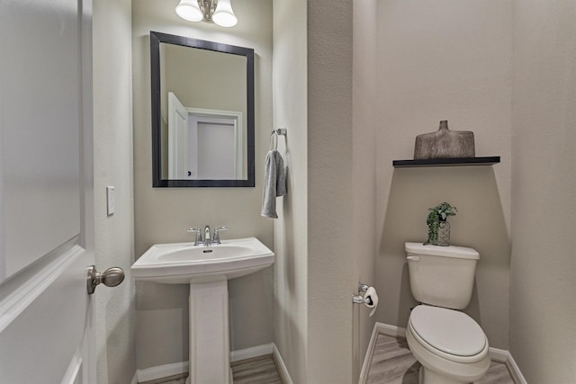 bathroom featuring sink, wood-type flooring, and toilet