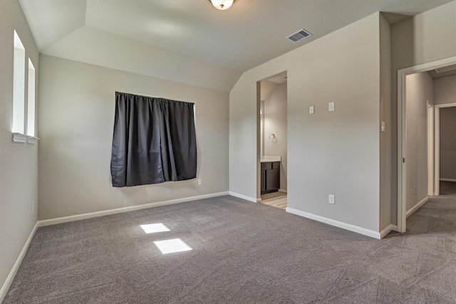 carpeted spare room featuring lofted ceiling