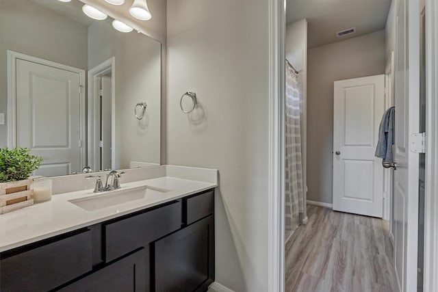 bathroom featuring hardwood / wood-style floors, vanity, and curtained shower