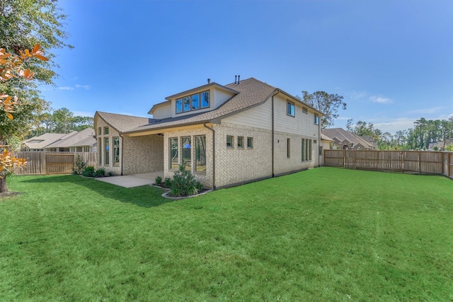 rear view of property with a yard and a patio area