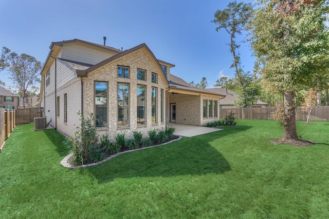 back of house with a lawn, a patio area, and central AC