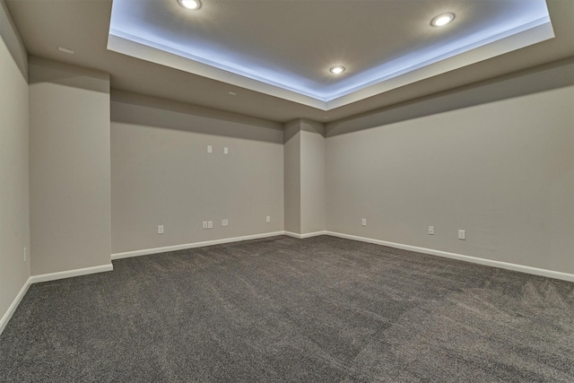 carpeted empty room with a tray ceiling