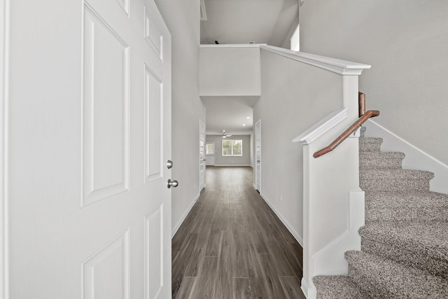 hallway with stairs, baseboards, and wood finished floors