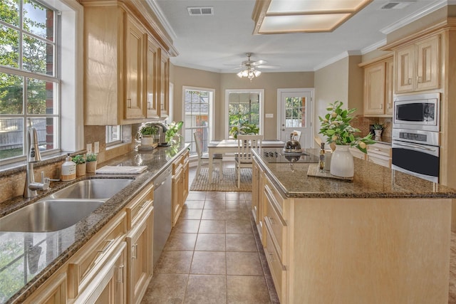 kitchen with appliances with stainless steel finishes, a center island, ceiling fan, and sink