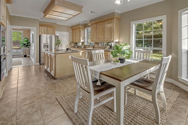 dining space with ornamental molding, sink, and light tile patterned floors