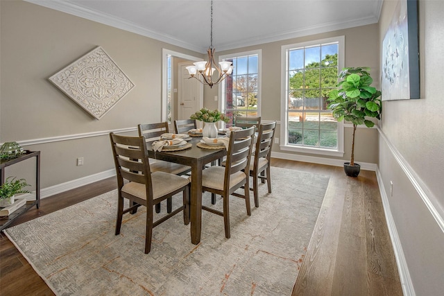 dining area featuring a chandelier, wood-type flooring, a wealth of natural light, and crown molding