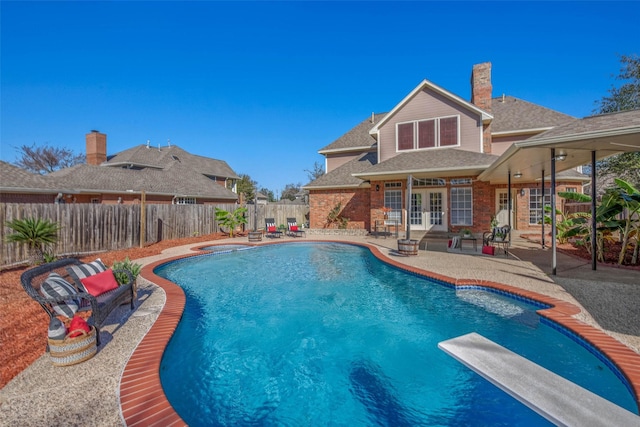 view of pool featuring a diving board, french doors, and a patio