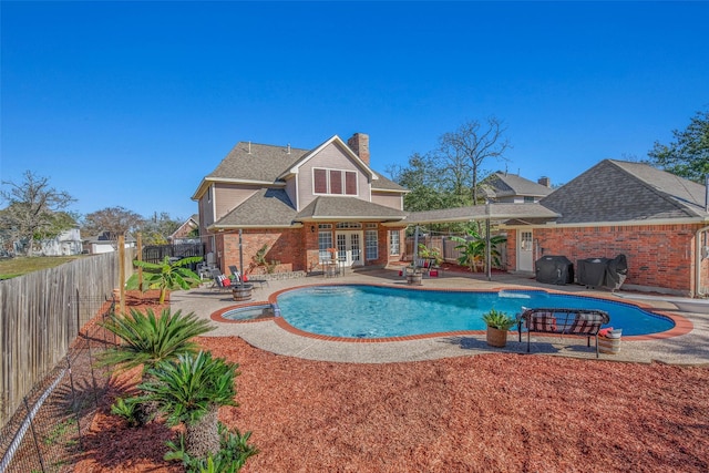 view of swimming pool with grilling area, an in ground hot tub, french doors, and a patio