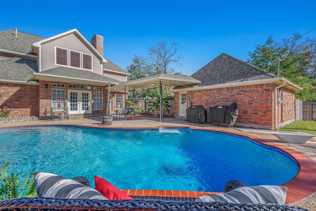 view of pool with a grill, a patio, and french doors