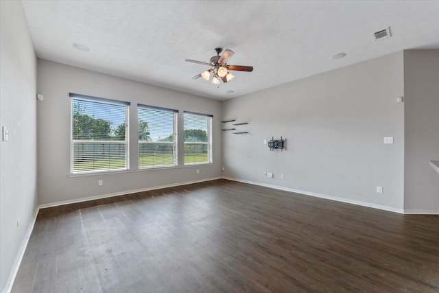 spare room featuring a textured ceiling, ceiling fan, and dark wood-type flooring