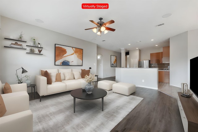 living room featuring light hardwood / wood-style flooring and ceiling fan