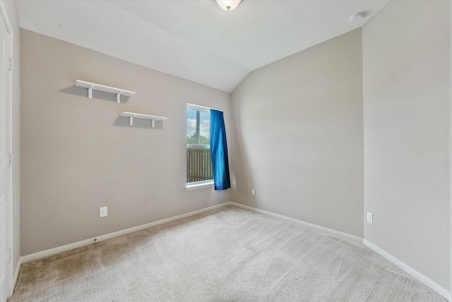 empty room with light carpet and vaulted ceiling