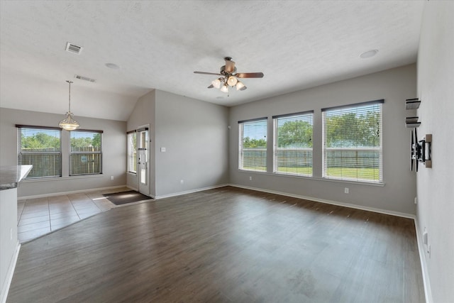 unfurnished living room featuring ceiling fan, dark hardwood / wood-style flooring, and vaulted ceiling