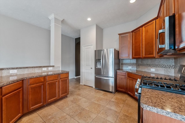 kitchen featuring appliances with stainless steel finishes, decorative columns, tasteful backsplash, light tile patterned floors, and stone counters