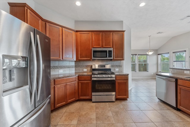 kitchen featuring light tile patterned floors, backsplash, stainless steel appliances, and lofted ceiling