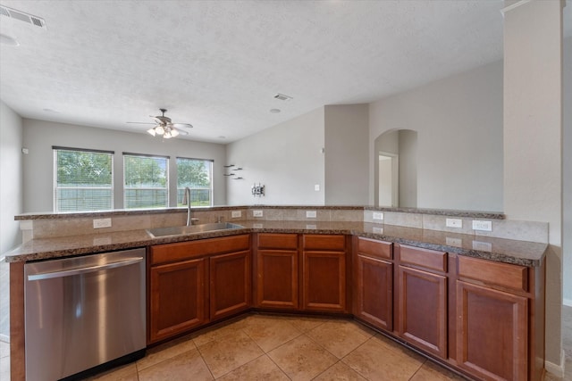 kitchen featuring sink, stainless steel dishwasher, ceiling fan, light tile patterned floors, and a textured ceiling