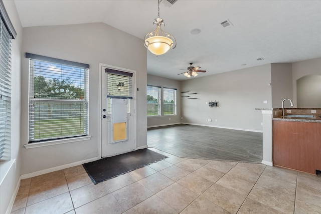 foyer entrance with ceiling fan, light tile patterned flooring, sink, and vaulted ceiling