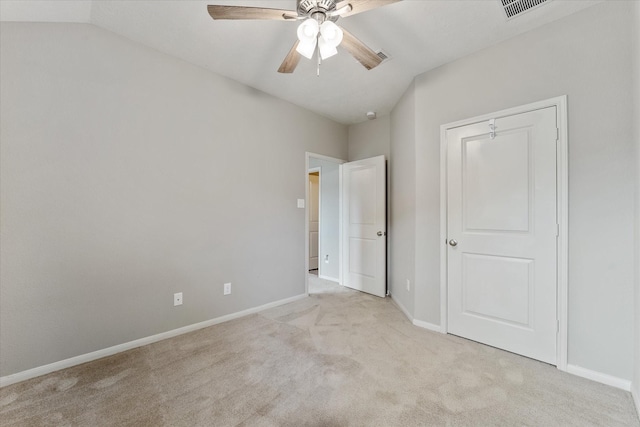 unfurnished bedroom with a closet, light colored carpet, ceiling fan, and lofted ceiling