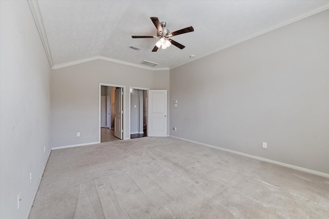 spare room featuring ceiling fan, light colored carpet, vaulted ceiling, and ornamental molding