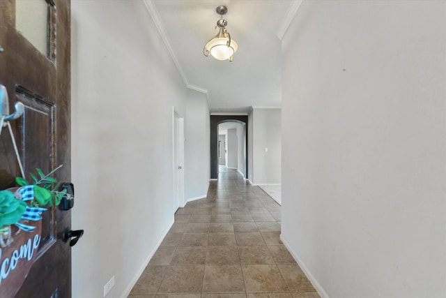 hallway with tile patterned floors and crown molding