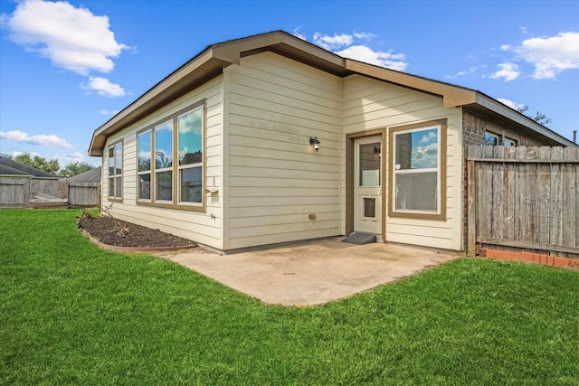 back of property featuring a patio area and a lawn