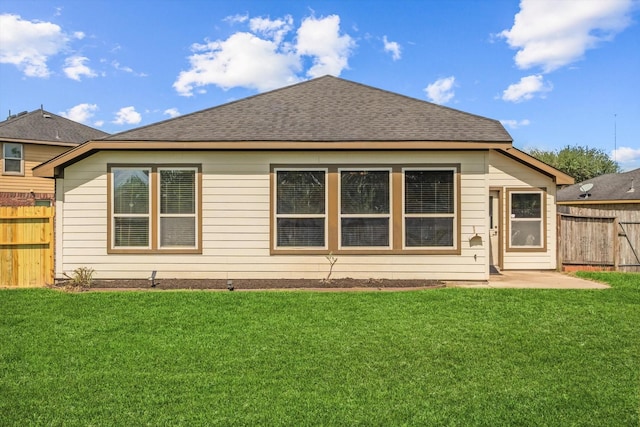 rear view of house featuring a lawn