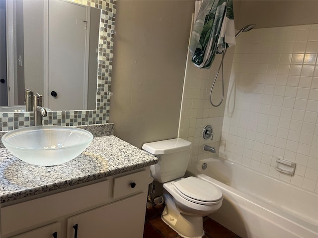 full bathroom with decorative backsplash, toilet, vanity, and tiled shower / bath