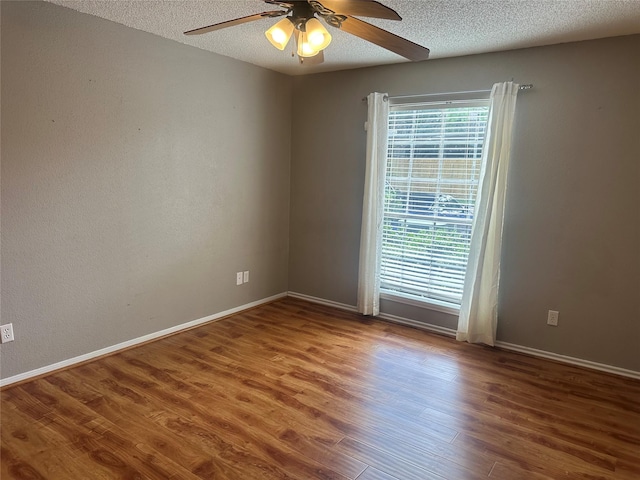 empty room with a textured ceiling, hardwood / wood-style flooring, and ceiling fan